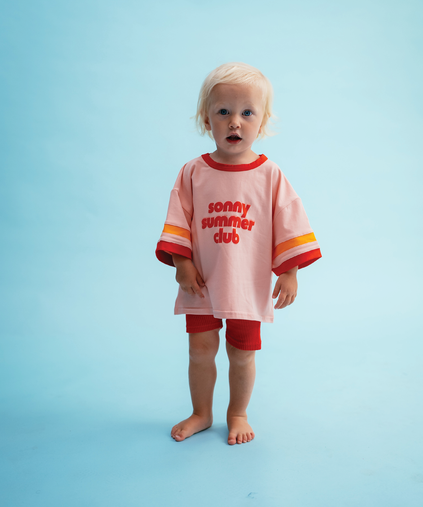 Child wearing Sonny Label Summer25 collection pieces on a sky blue background.