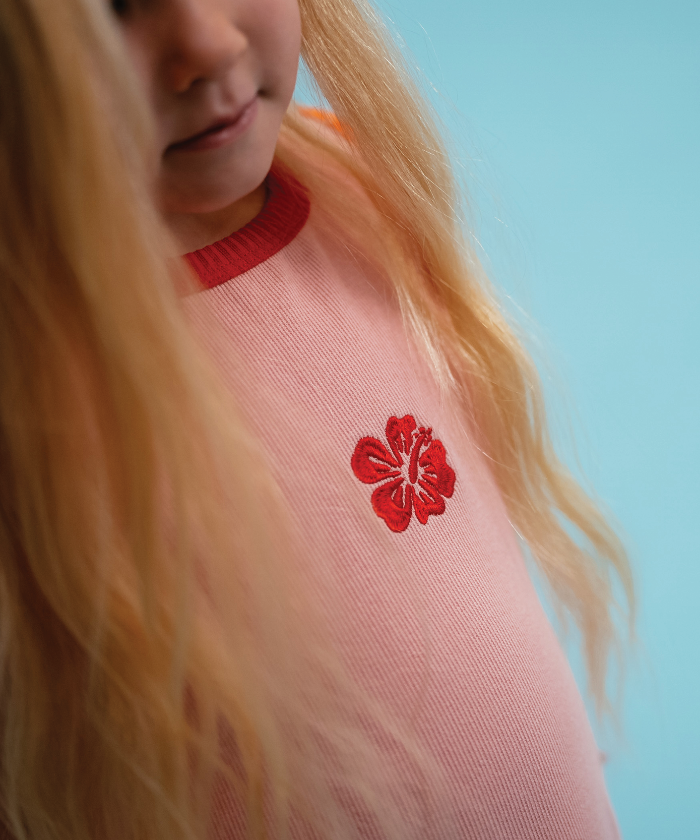 Child in Sonny Label Summer25 collection pieces on a vivid sky blue background.