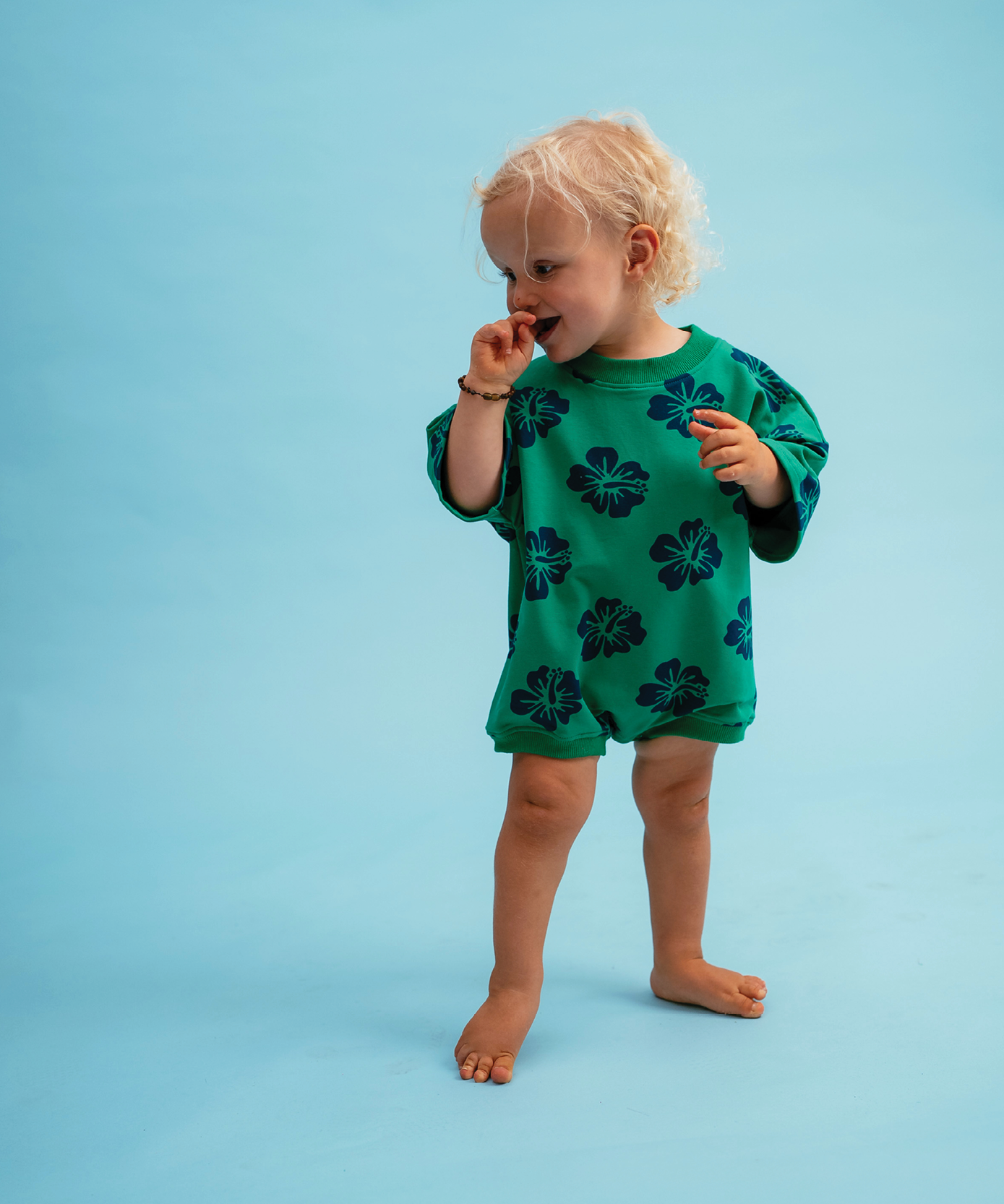 Child in Sonny Label Summer25 collection pieces on a sky blue background.