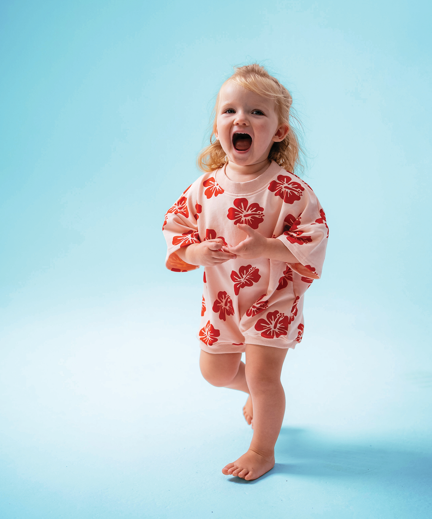 Child in Sonny Label Summer25 collection pieces on a vivid sky blue background.
