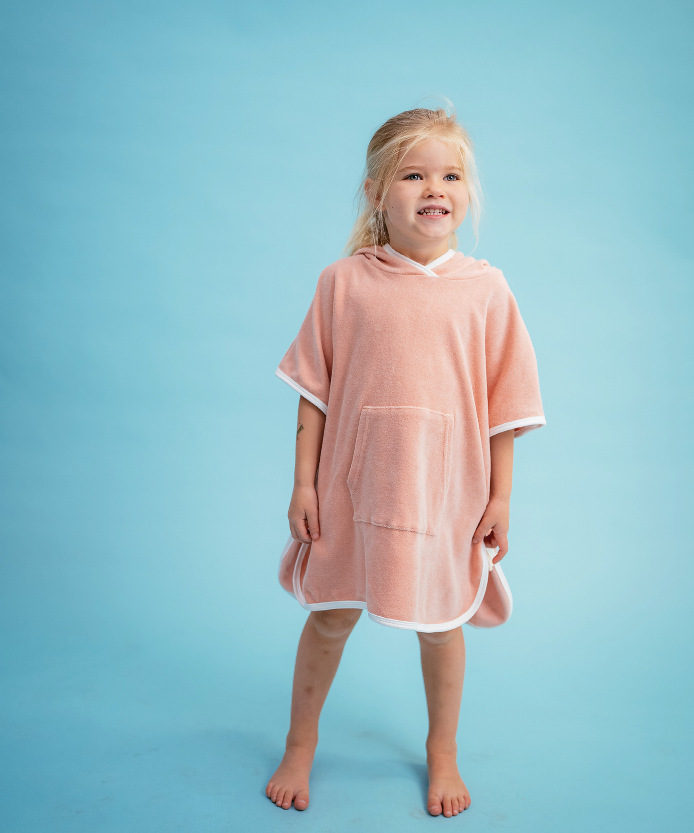 Child in Sonny Label Summer25 collection pieces on a sky blue background.