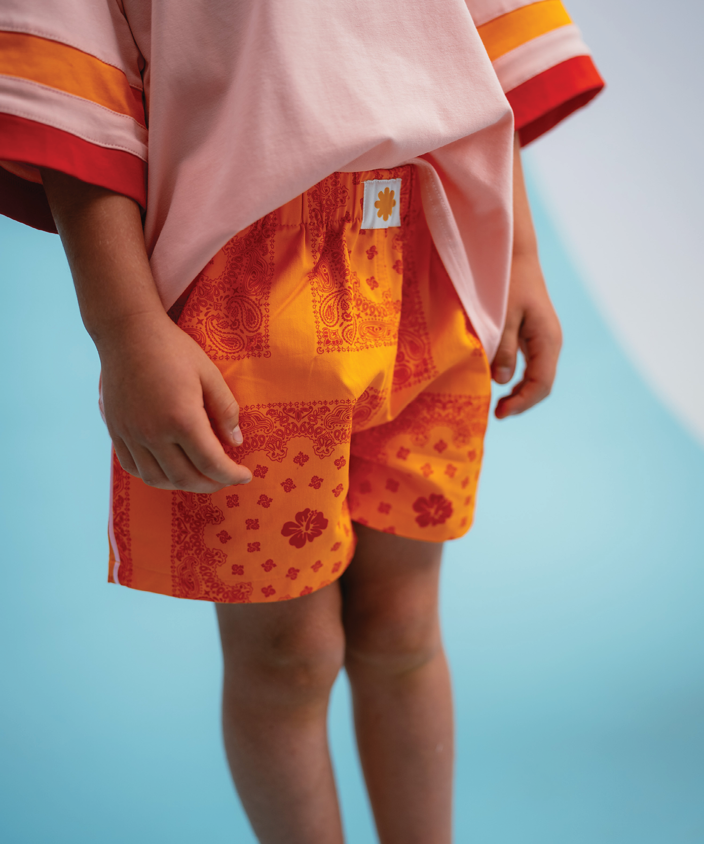 Child wearing Sonny Label Summer25 collection piece on a sky blue background.