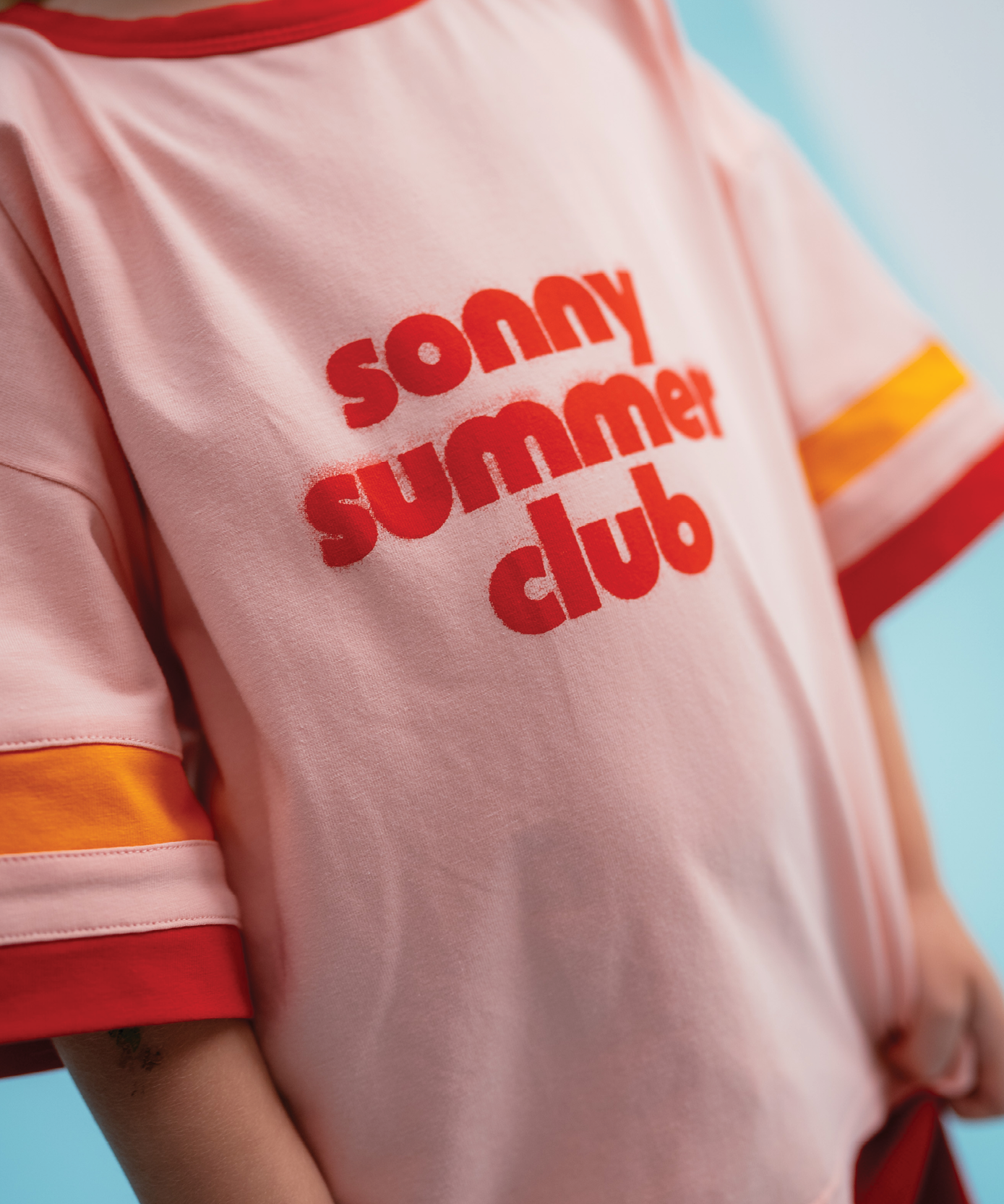 Child wearing Sonny Label Summer25 singlet and swimwear on a sky blue background.