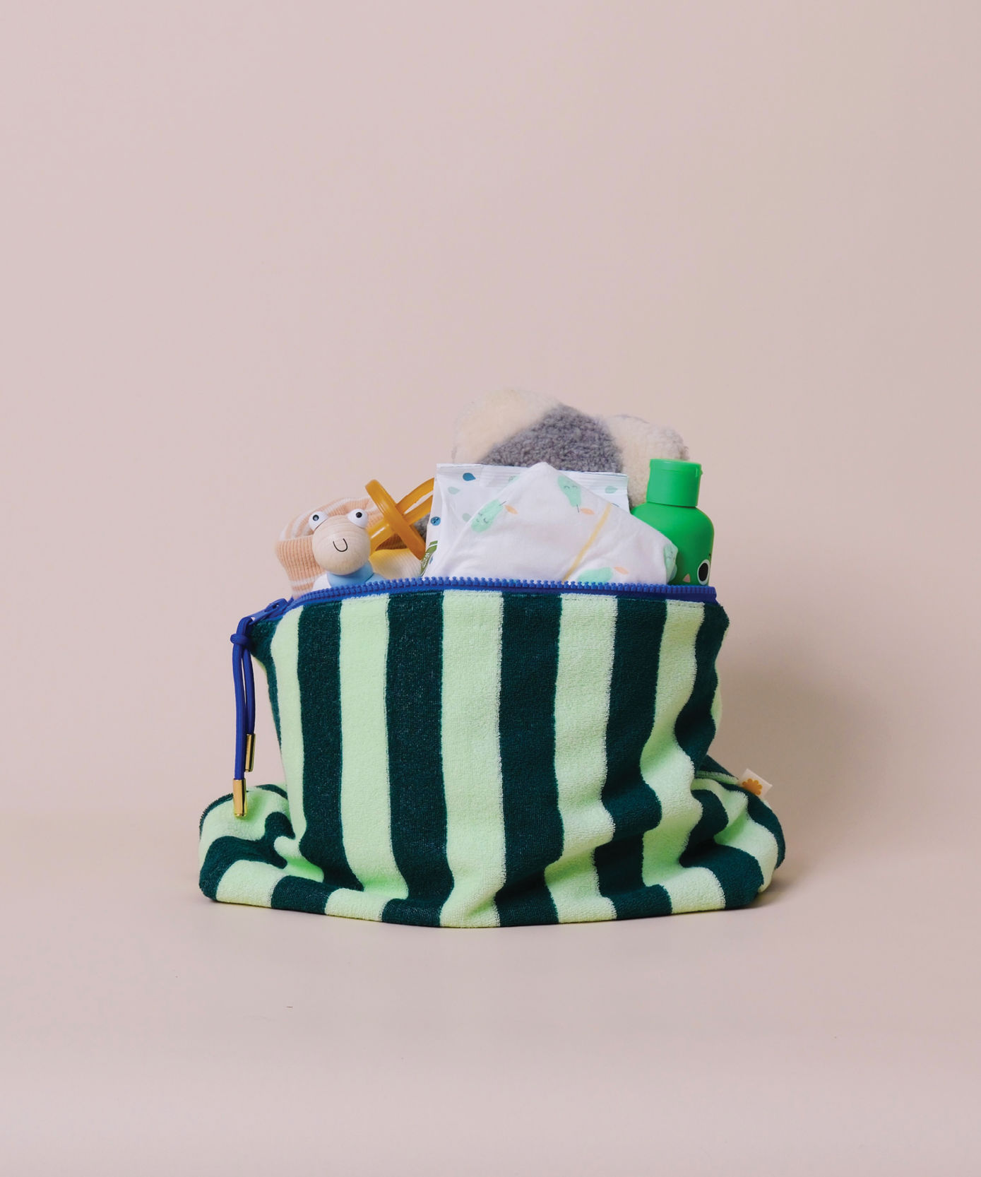 Sonny Label red and pink stripe terrycloth zip pouch with bright orange zip, flat lay on a grey background.