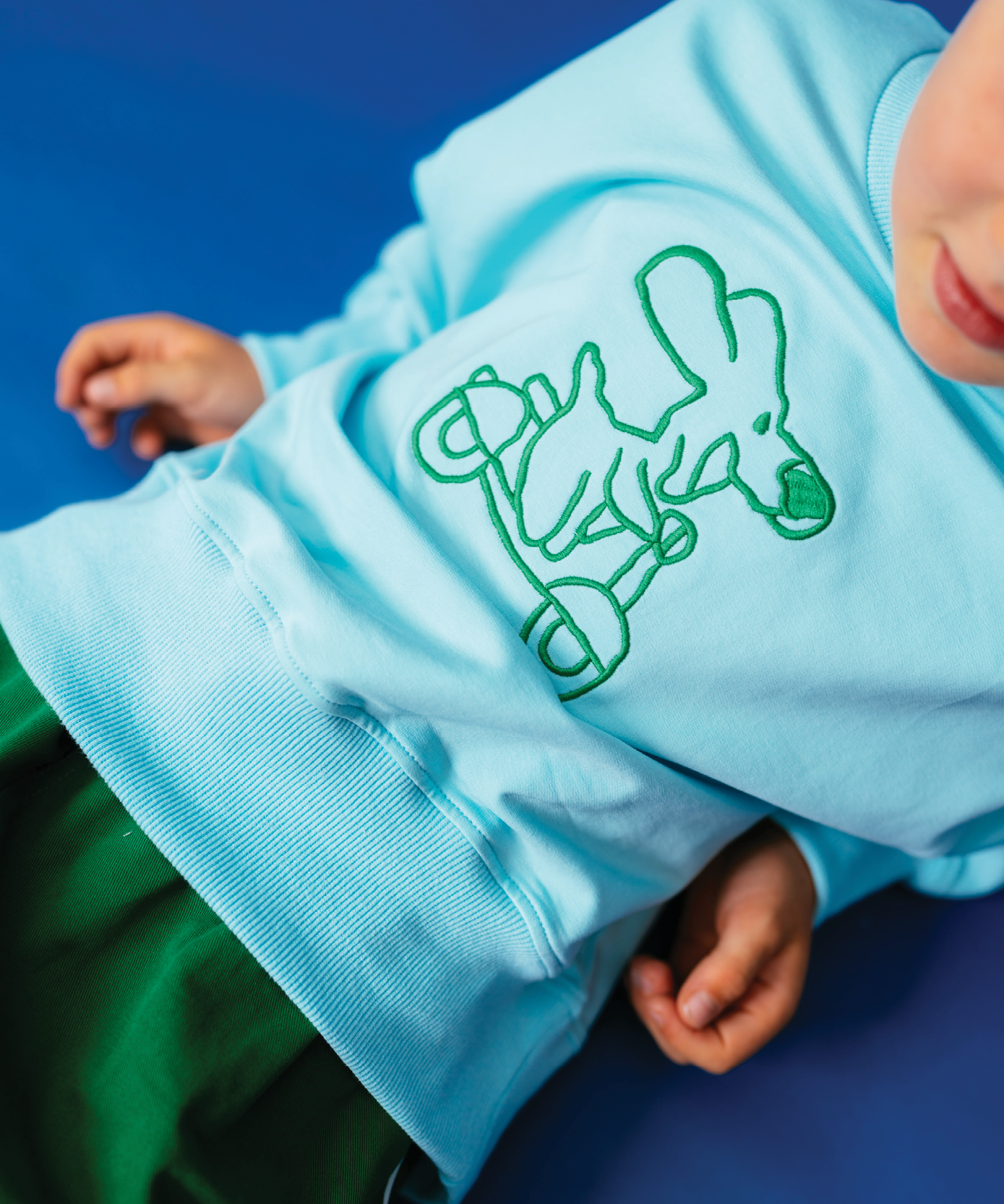 Child in Sonny Label Circus26 kids outfit on a vivid blue background. Variant upload.