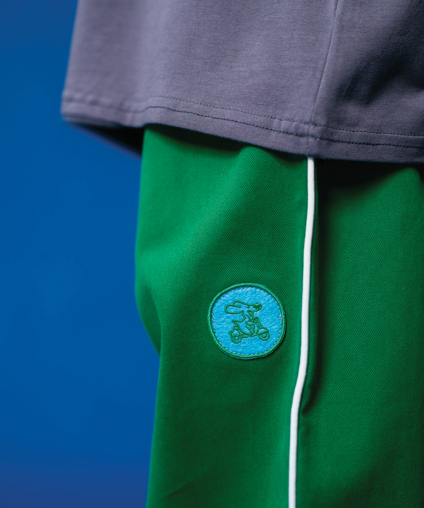 Child wearing Sonny Label Circus26 collection pieces posed on a vivid blue studio backdrop.
