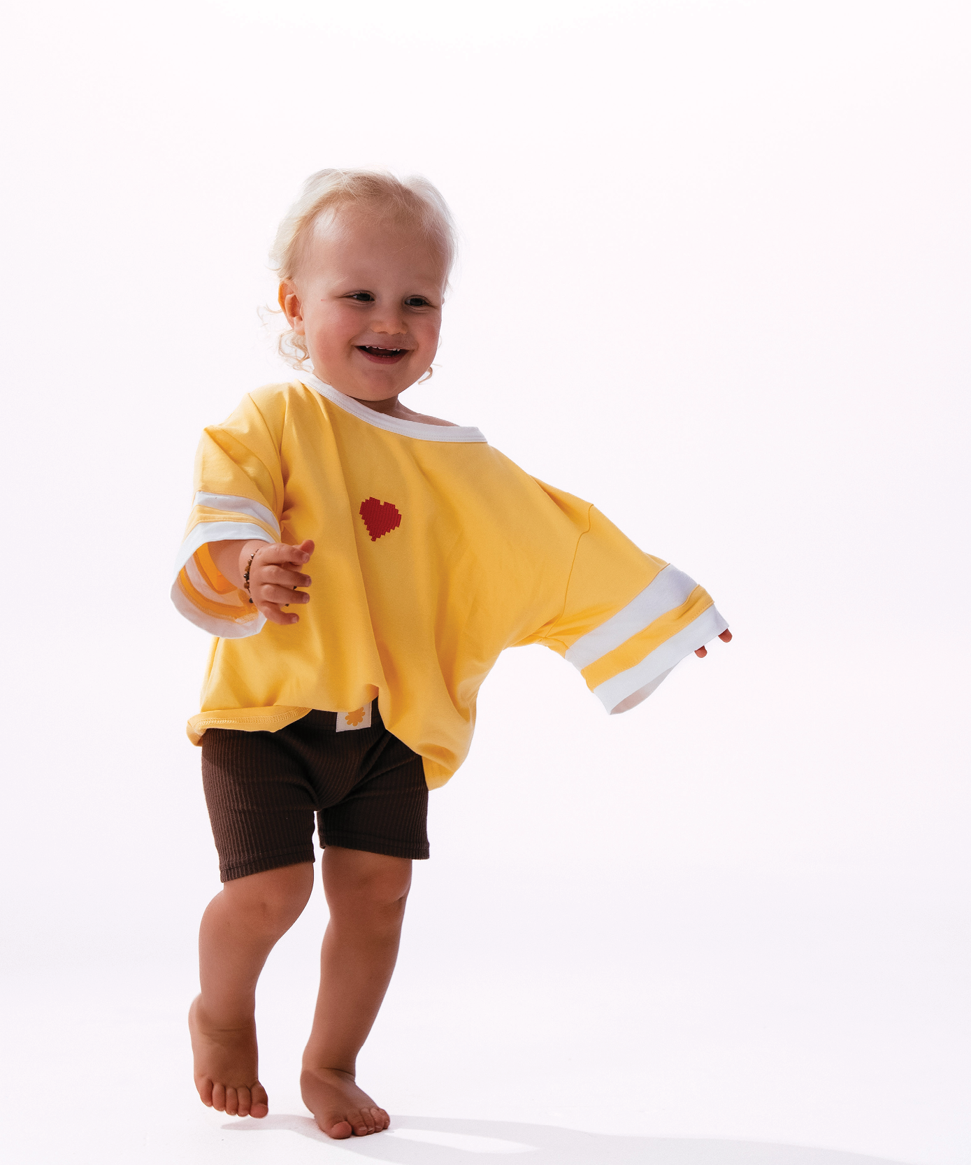 Child in Sonny Label LOVER collection yellow crop tee on a soft white background.