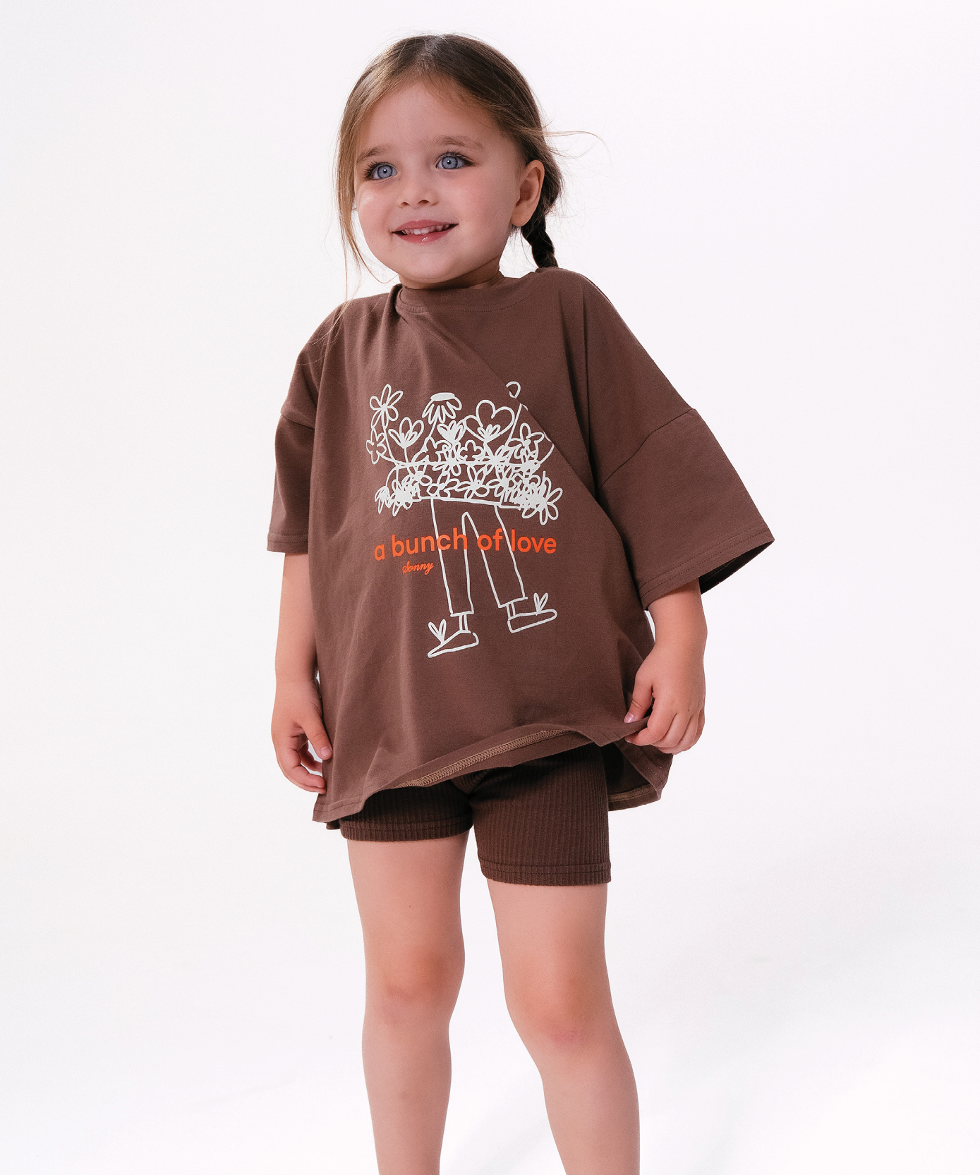 Child wearing Sonny Label LOVER collection pieces on a soft white studio background.