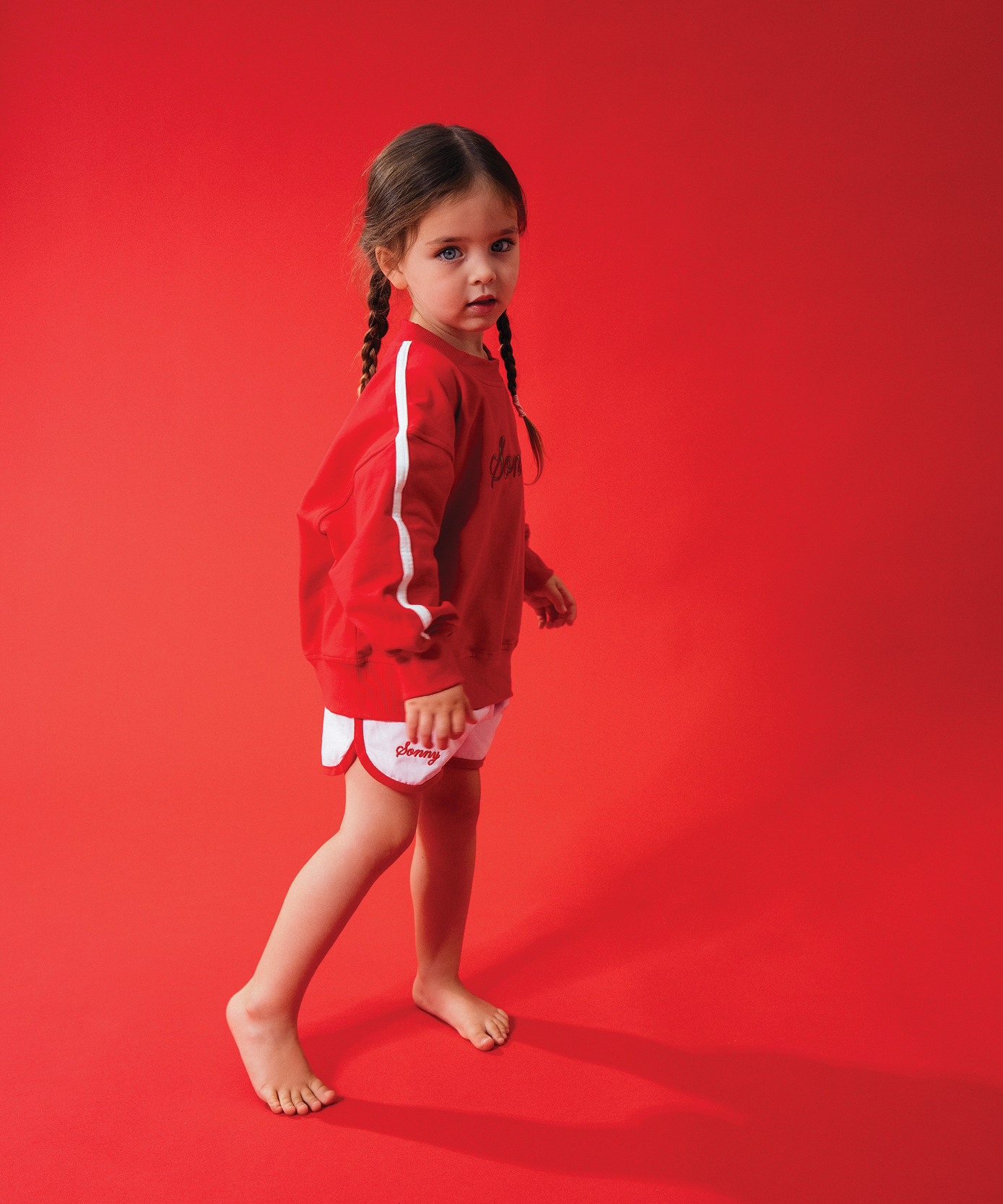 Child in Sonny Label LOVER collection yellow crop tee and shorts on a light grey background.