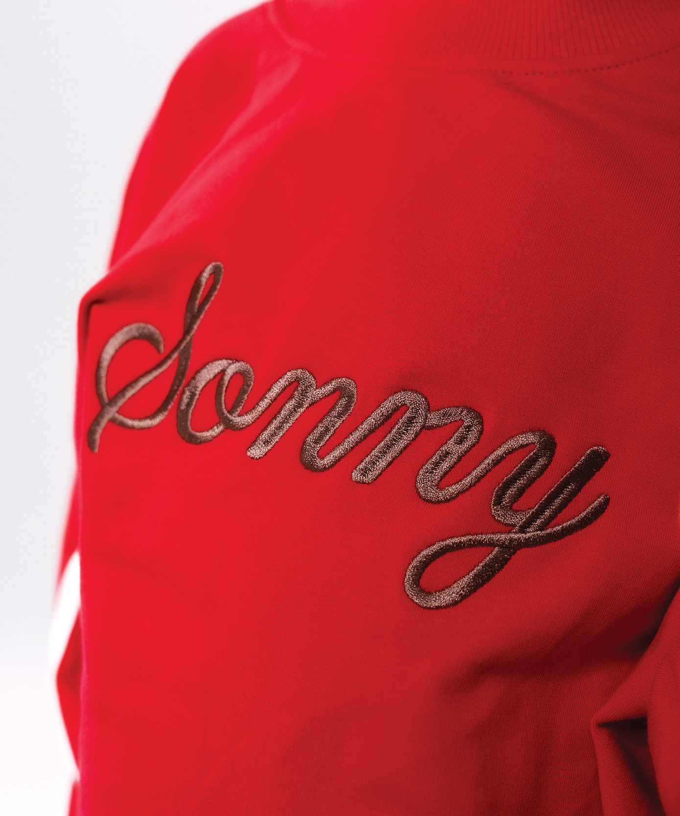 Child wearing Sonny Label LOVER collection pieces with pixel heart embroidery on a soft white background.