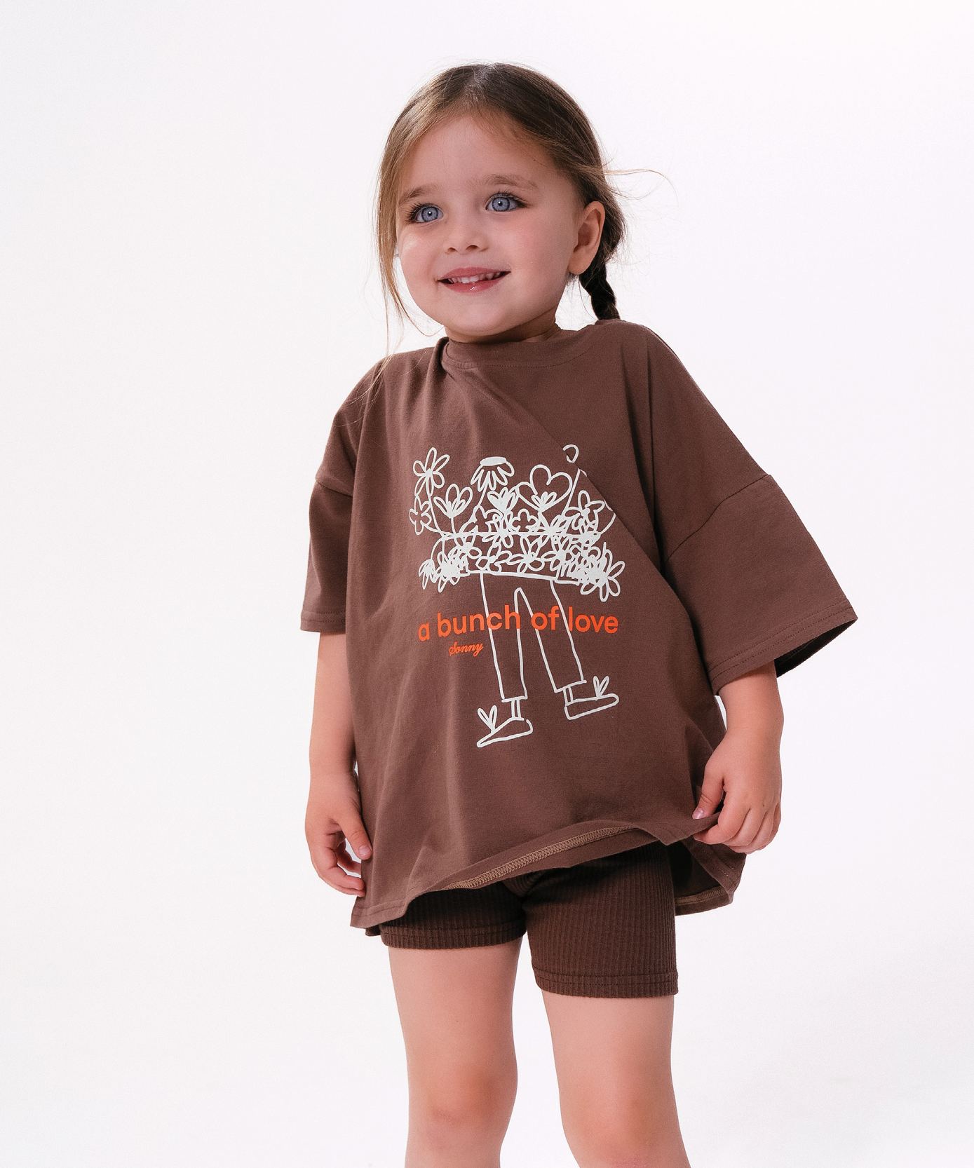 Child wearing Sonny Label LOVER collection outfit with pixel heart embroidery on a soft white background.