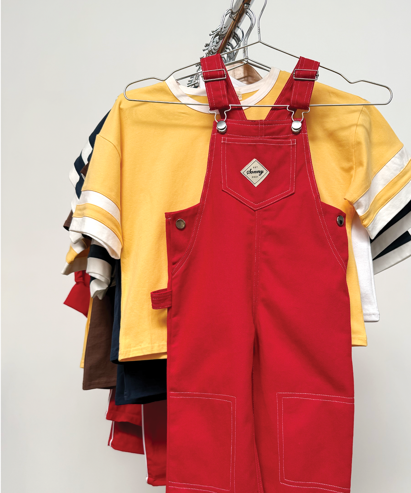 Child wearing Sonny Label LOVER collection pieces on a light grey studio backdrop.